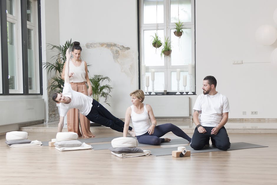 Adults practicing yoga with an instructor in a bright, modern studio with plants.