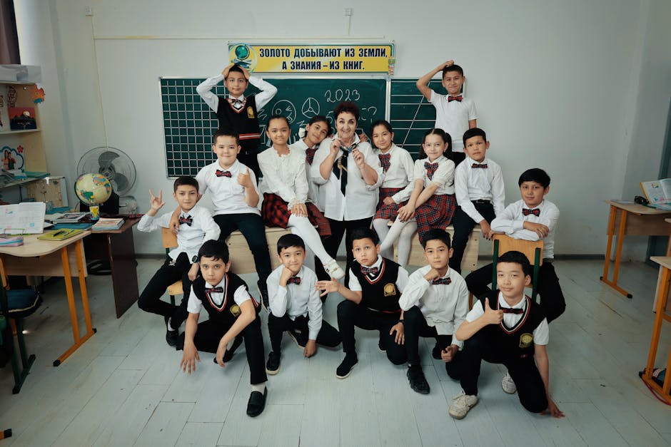 A diverse group of students in uniforms posing with their teacher in a classroom setting.