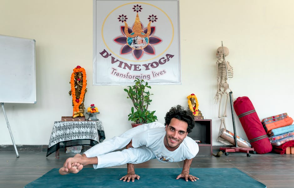 Man practicing eight angle yoga pose with a smile in a serene studio setting.